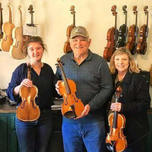 Samantha, Owner hold music instruments with friends